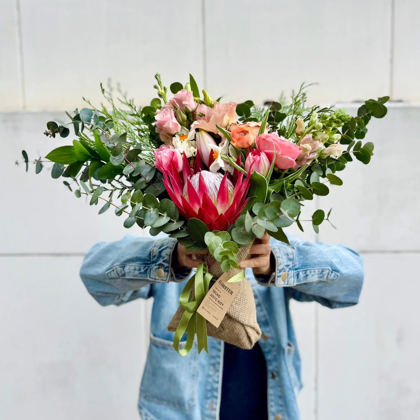 Ramo de flores de temporada en colores rosado y naranja. Con protea, lisianthus, rosas, tulipanes, ranunculos, eucalipto y lilium.