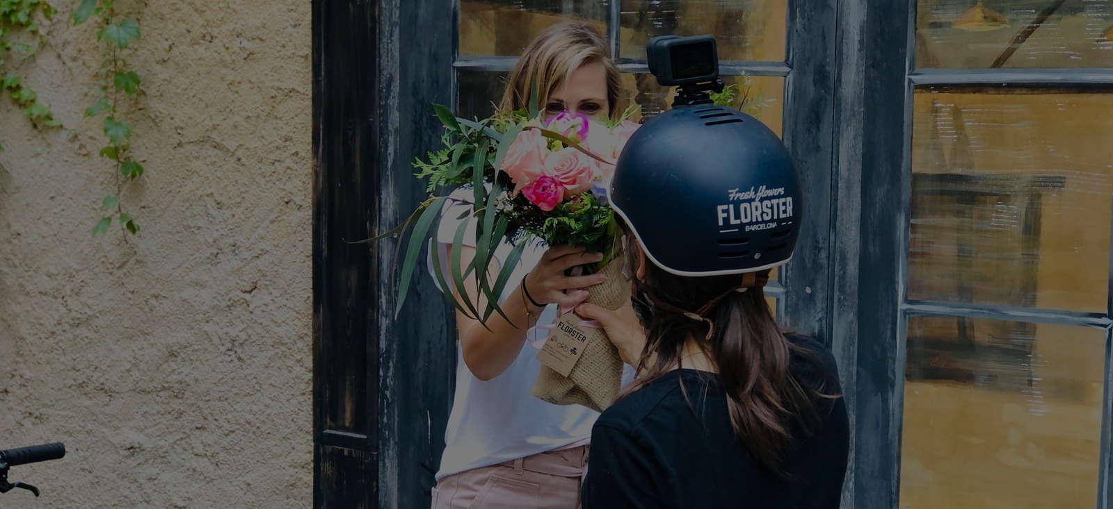 Mensajera de Florster en una entrega de flores a una chica en una calle de Barcelona.
